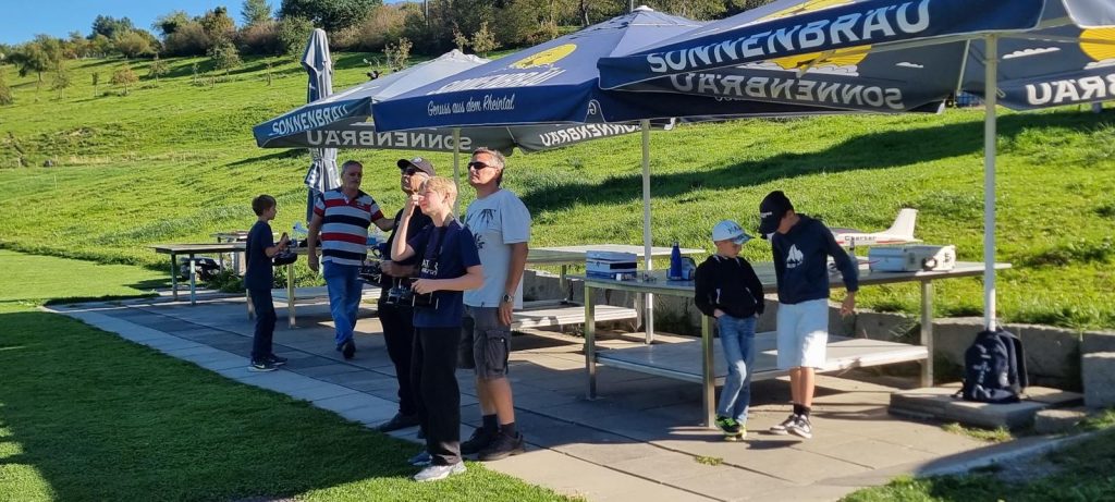 Gruppe mit Sendern unter den Sonnenschirmen beim Flugbetrieb